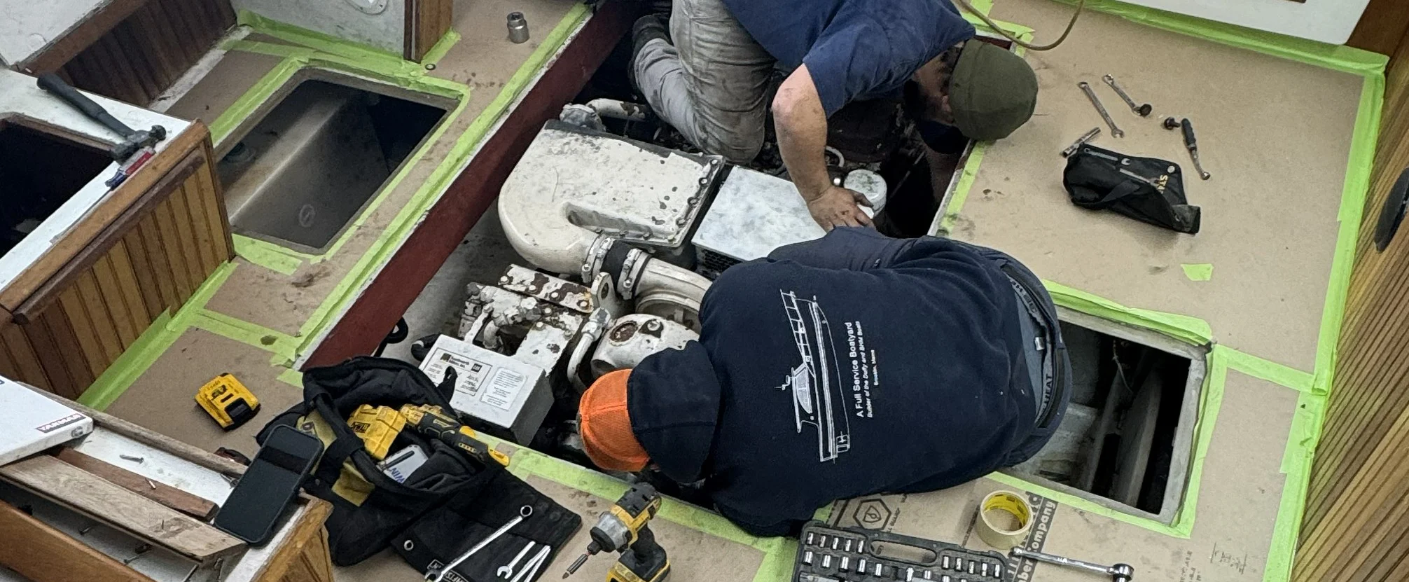 Two men working on the mechanics of a boat